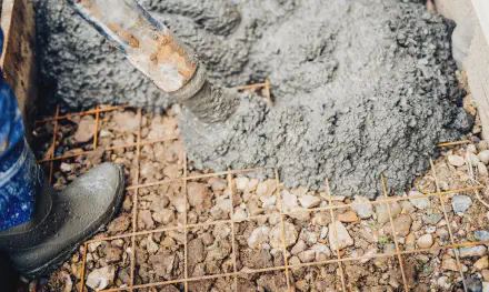 close up of construction workers using cement pump